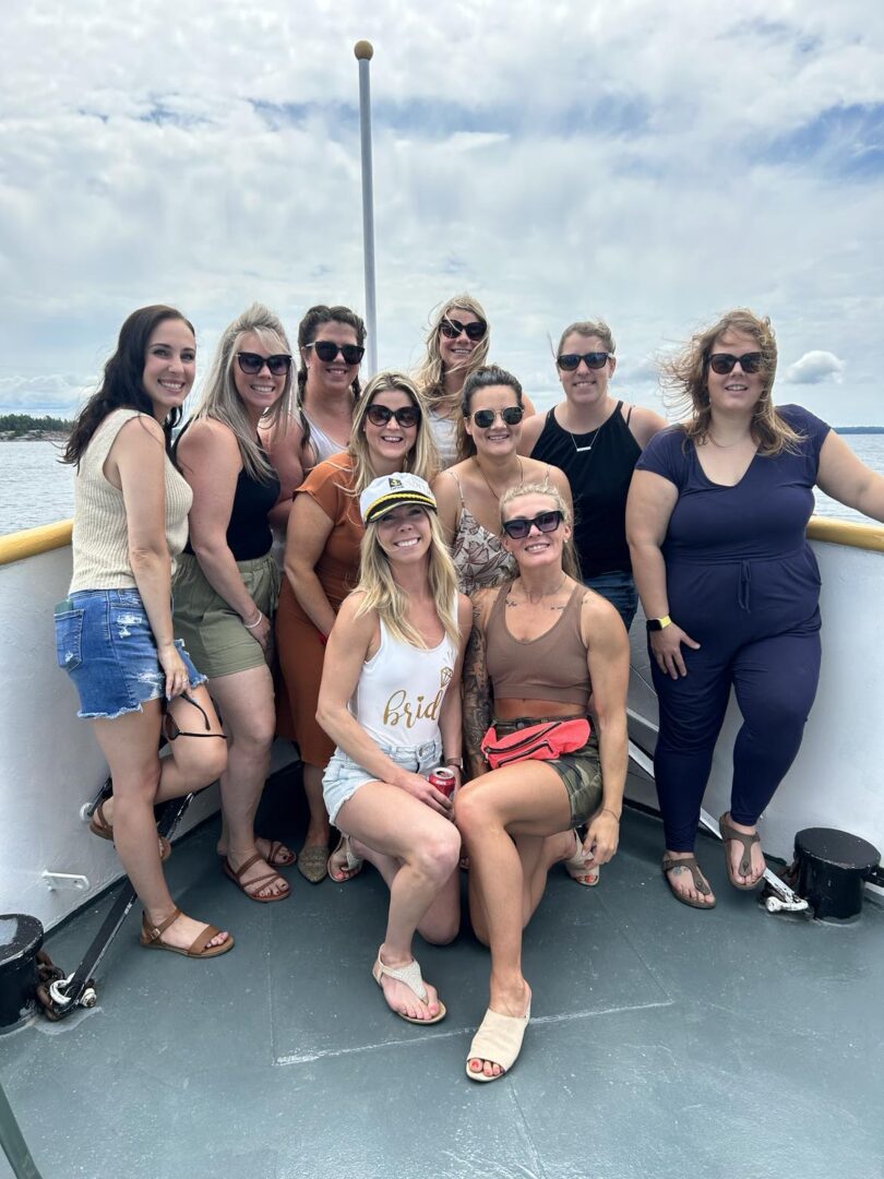 A group of women posing for the camera on a boat.